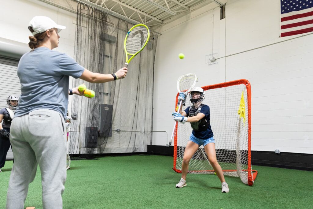 Lacrosse goalie practicing saves indoors during training.