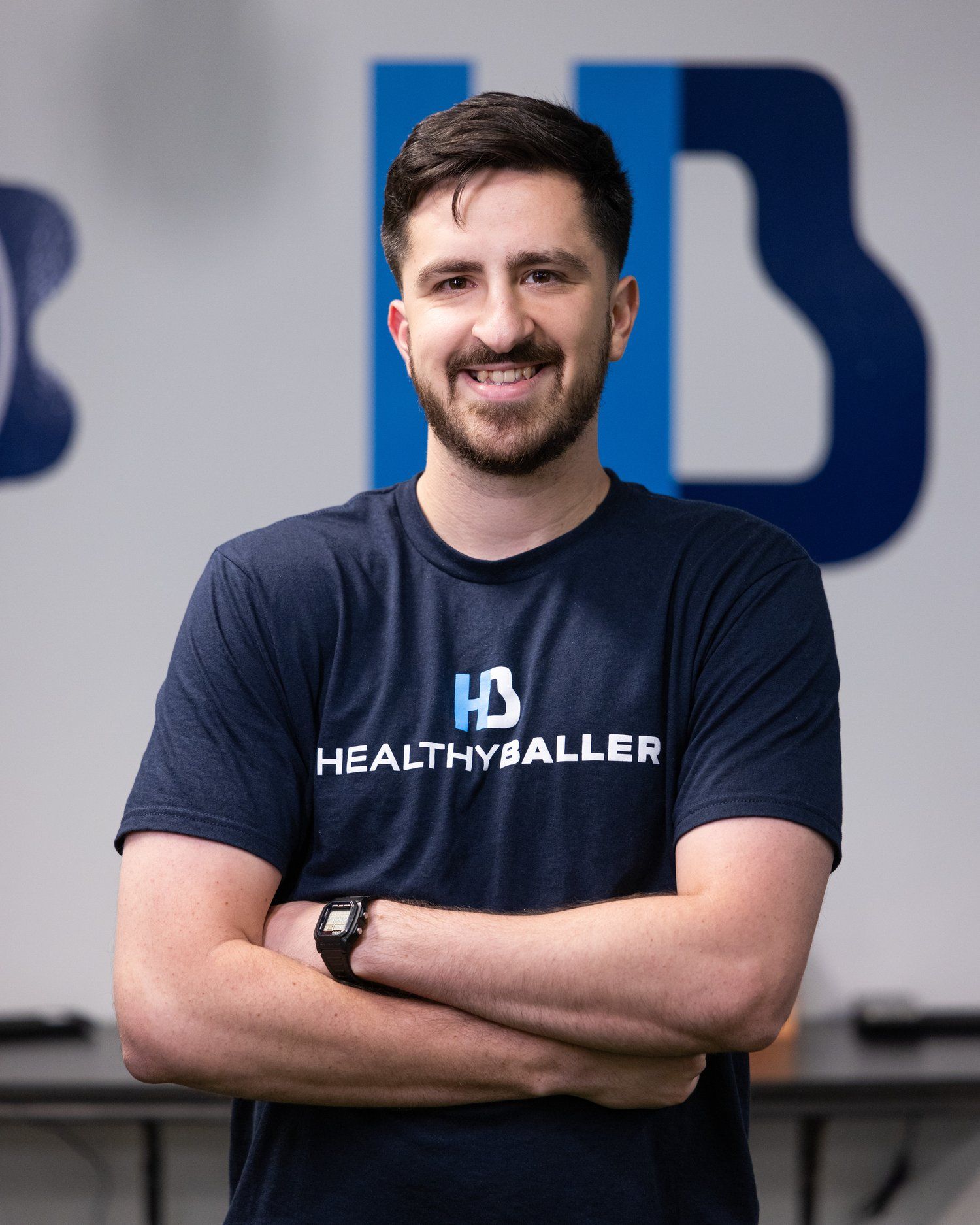 Smiling man wearing 'Healthy Baller' shirt.