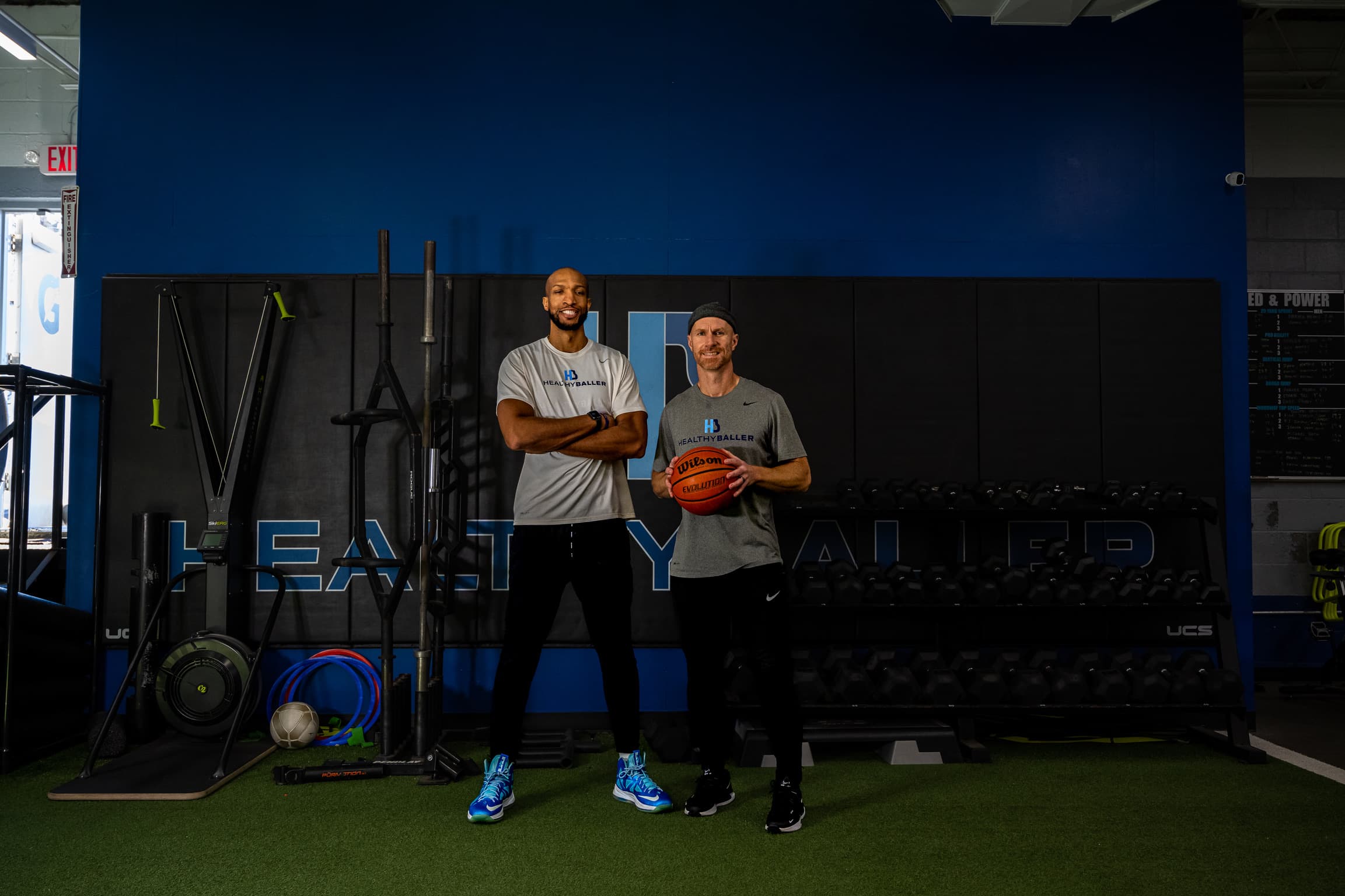 Two men holding basketball in a gym