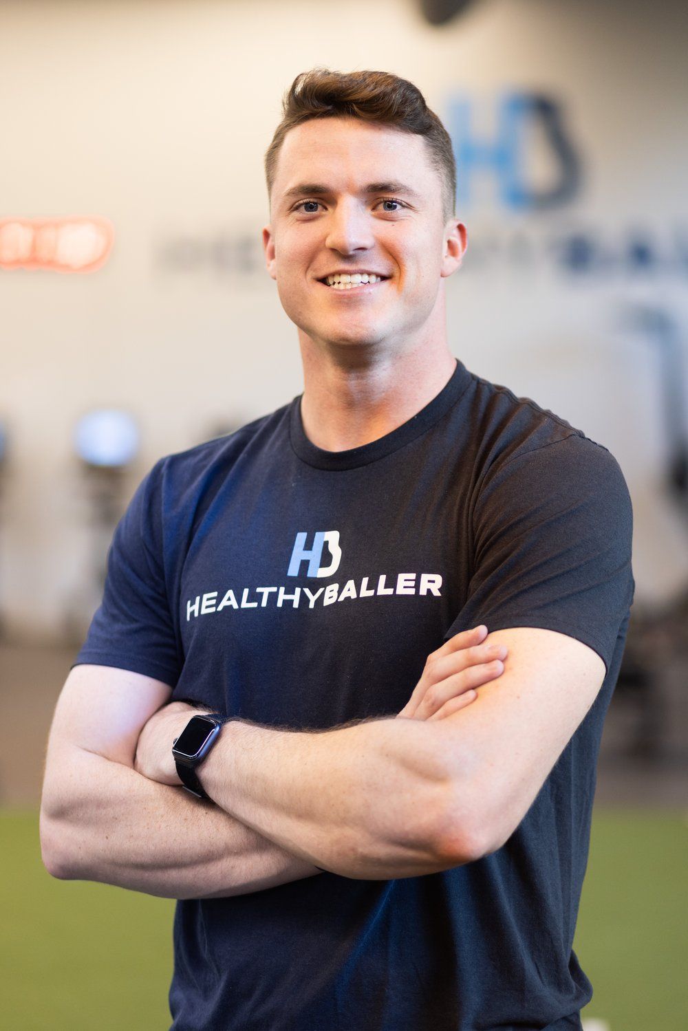 Smiling person wearing HealthyBaller T-shirt indoors.