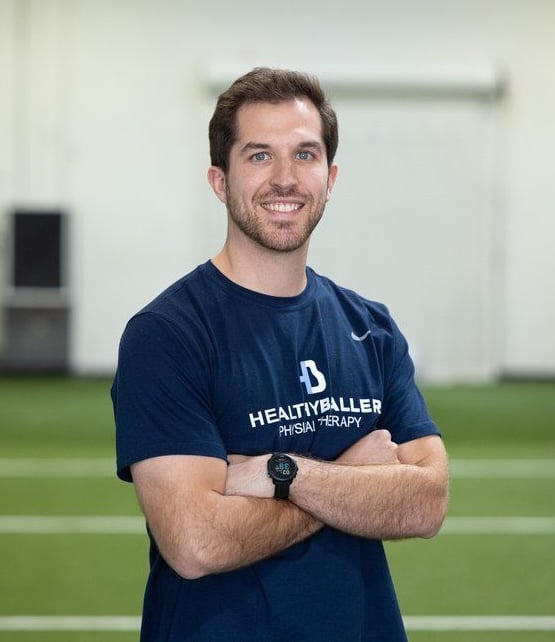 Man in athletic shirt smiling at gym.