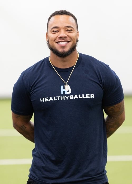 Smiling man in Healthy Baller T-shirt indoors.
