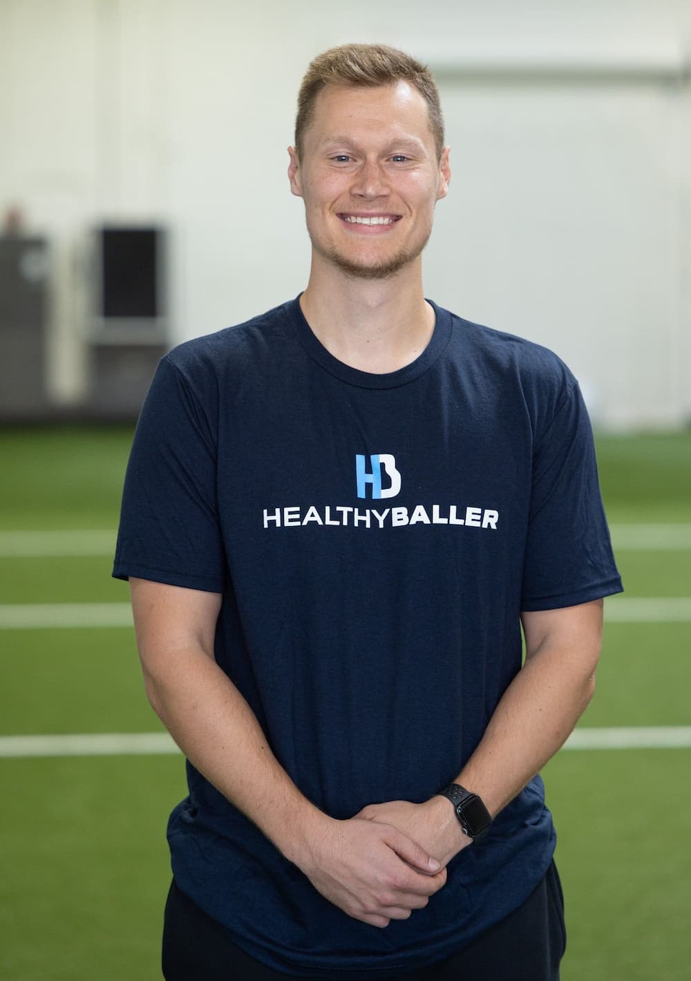 Man in Healthy Baller shirt smiling on field