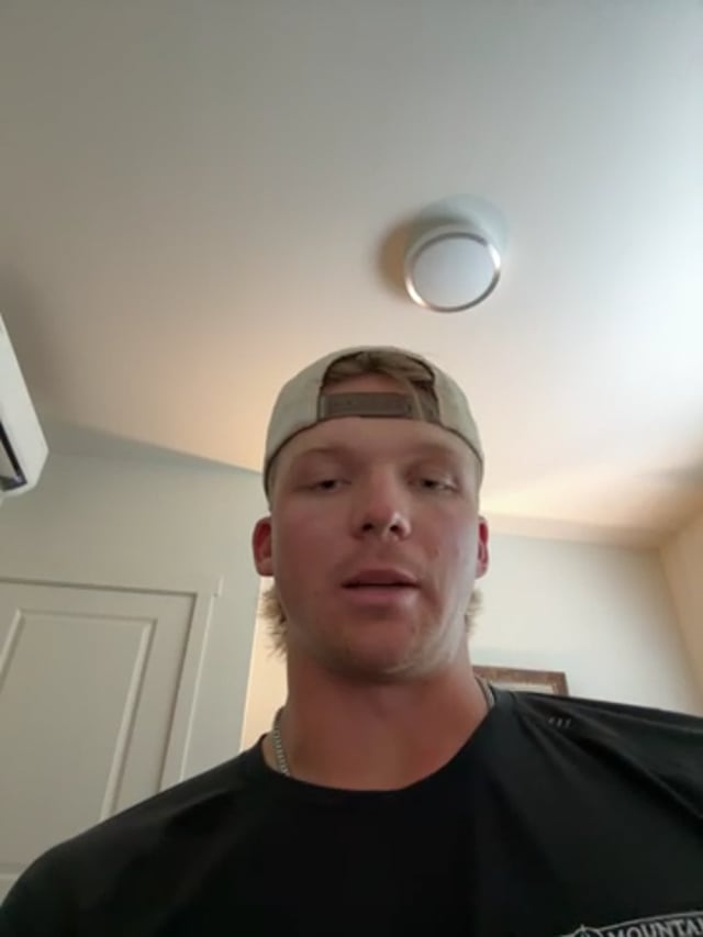 Person wearing cap indoors with ceiling light.