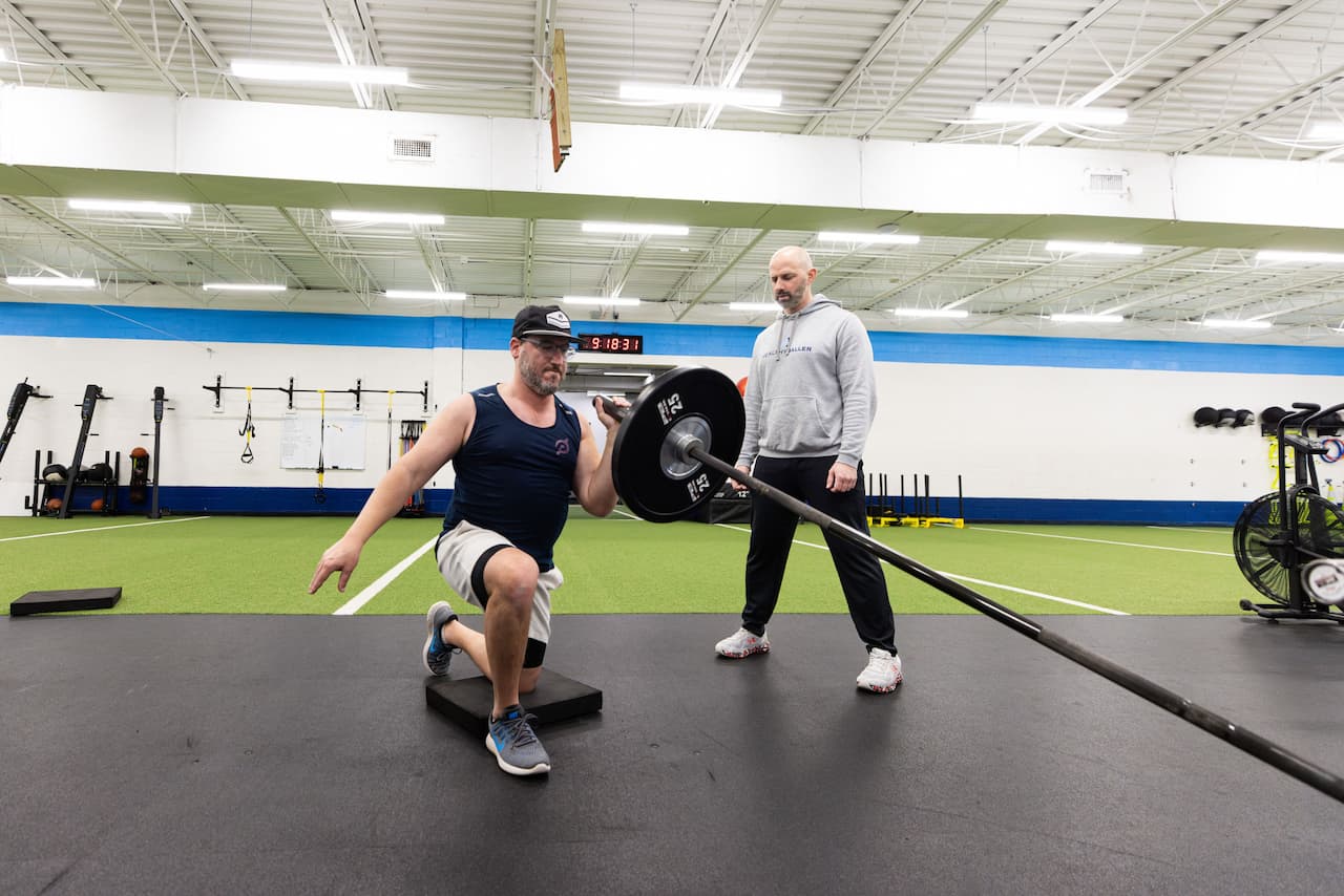 Man performing landmine press in gym