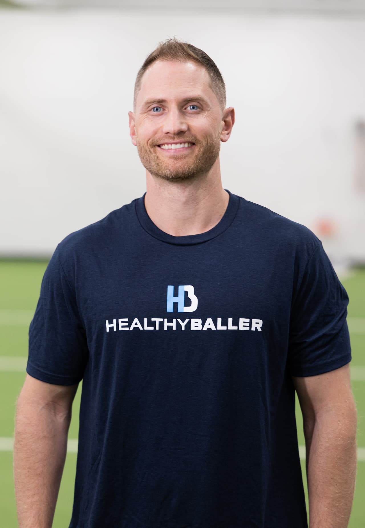 Man wearing Healthy Baller t-shirt, smiling.