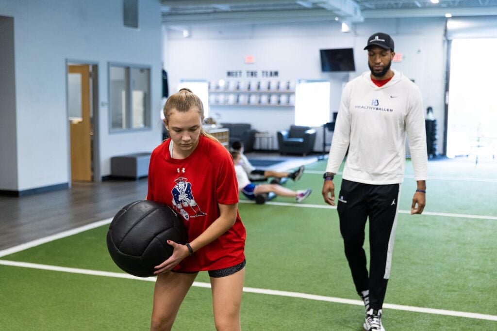 Woman exercising with medicine ball at gym.