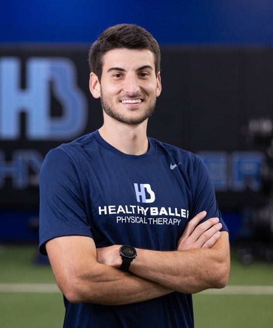 Person in Healthy Baller shirt smiling at gym