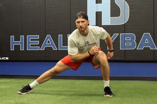Man stretching in gym, preparing for workout.