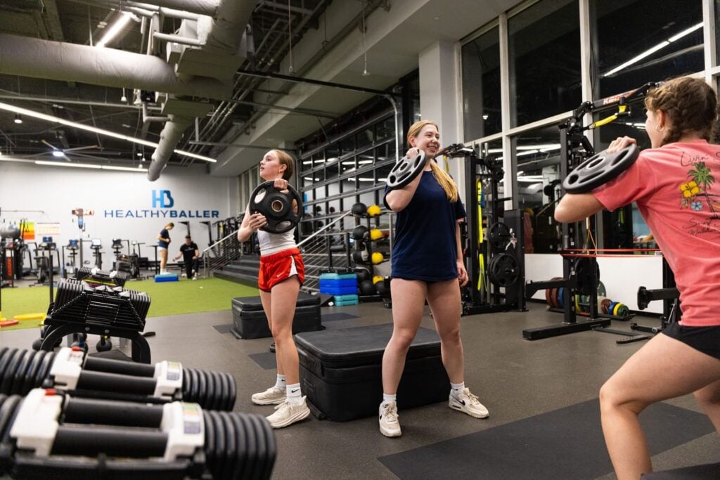 People exercising with weights in gym studio.