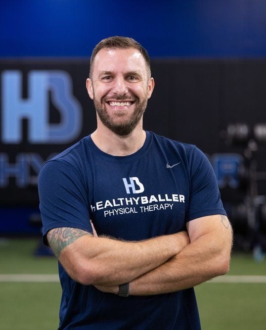 Smiling physical therapist in gym setting.