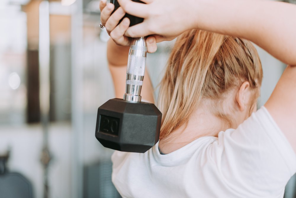 Woman exercising with dumbbell in gym