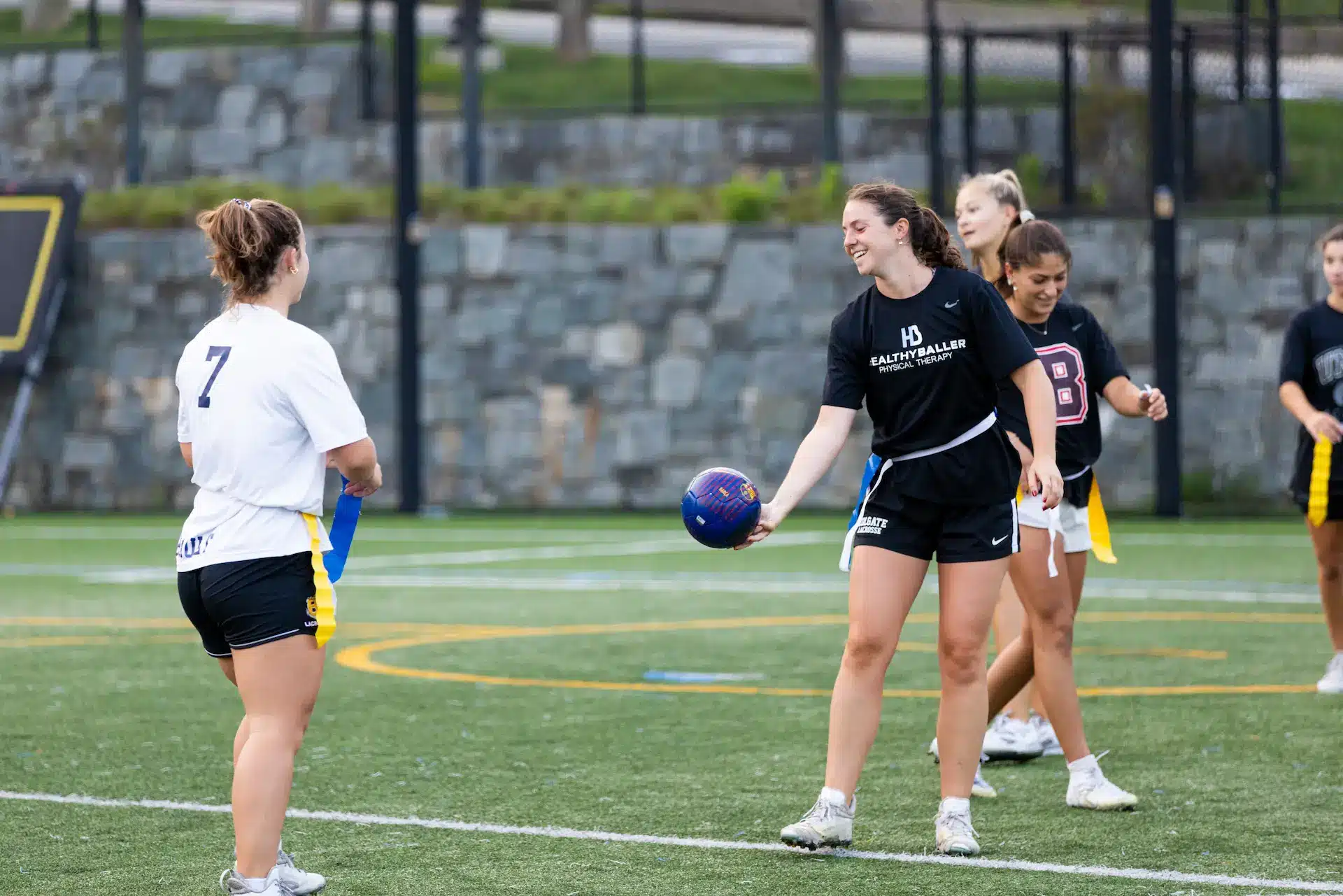 Women playing flag football on field