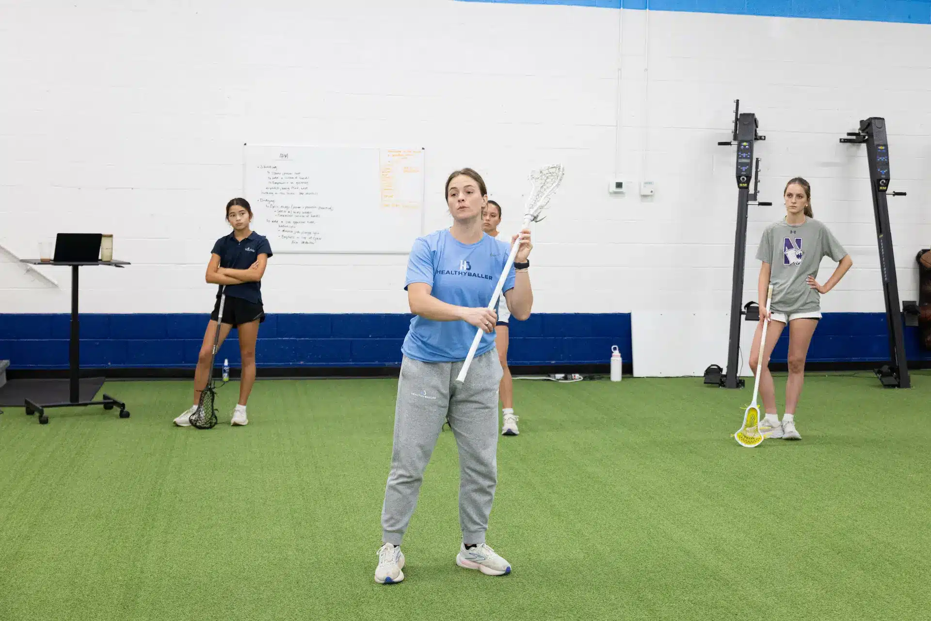 Women learning lacrosse in a sports facility