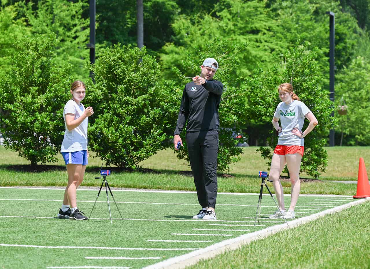 Coach instructing athletes on running track.