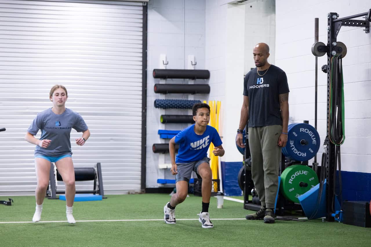 Athletes training in gym with coach guidance.