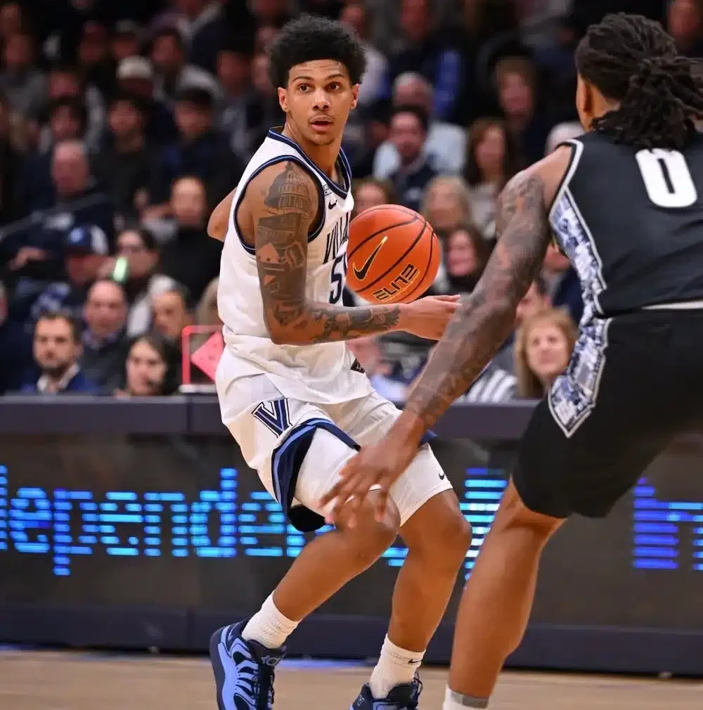 Basketball player dribbles ball on court during game.