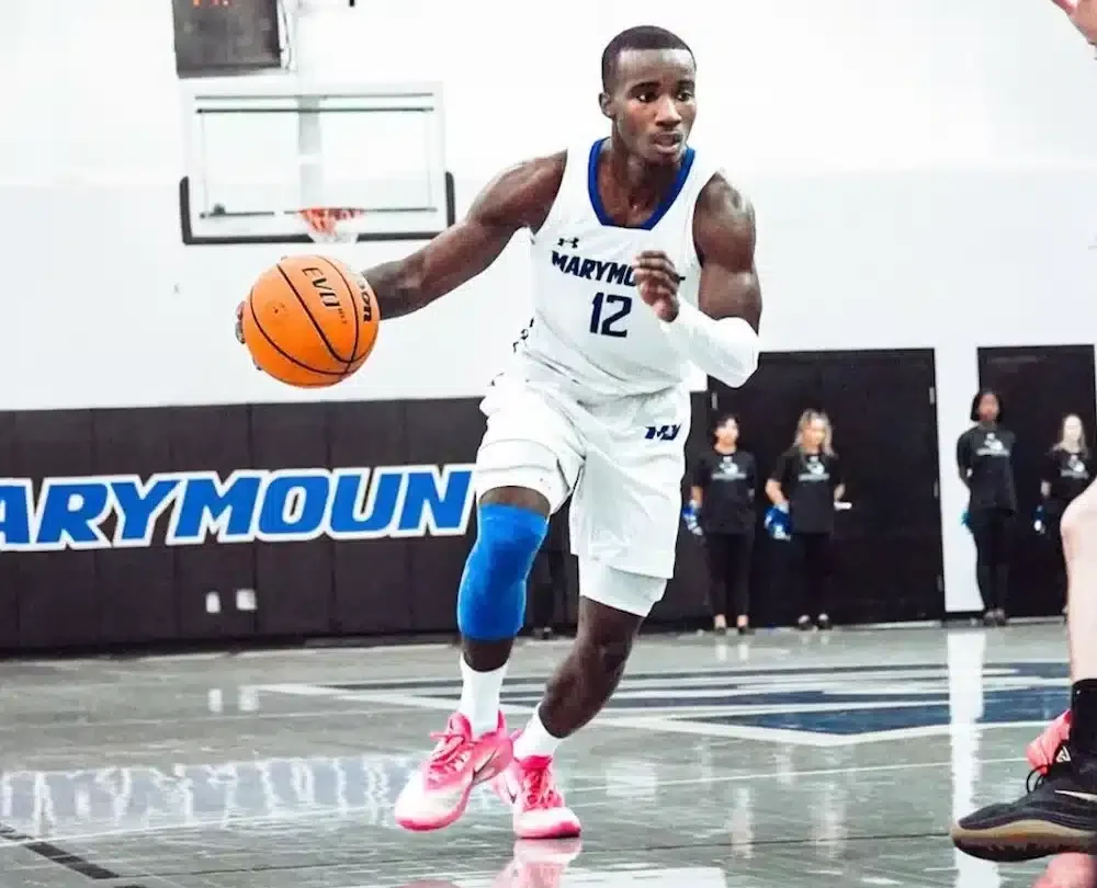 Basketball player dribbling on court during game.