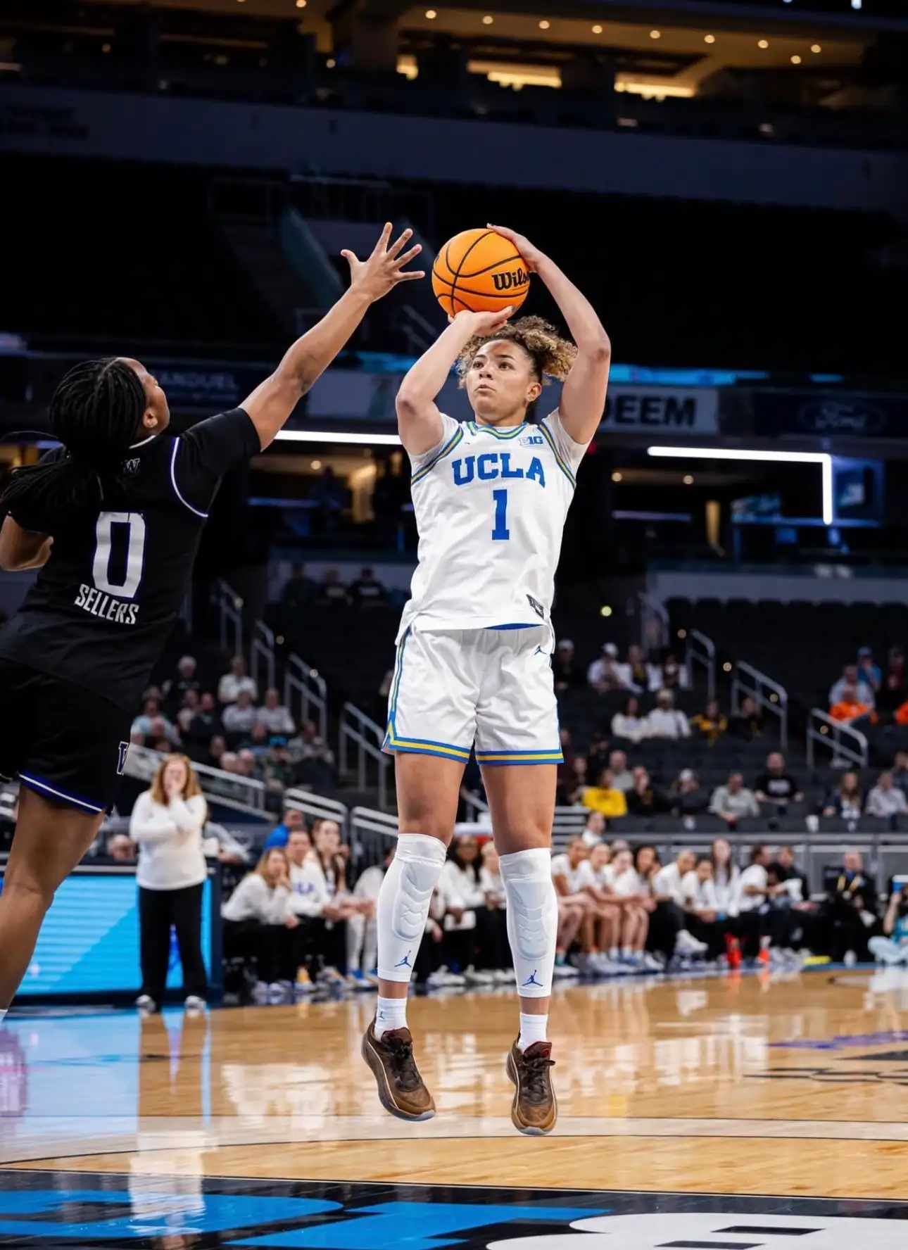 UCLA player jumping for basketball shot on court.