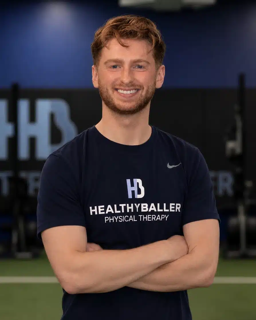 Smiling physical therapist wearing branded shirt in gym