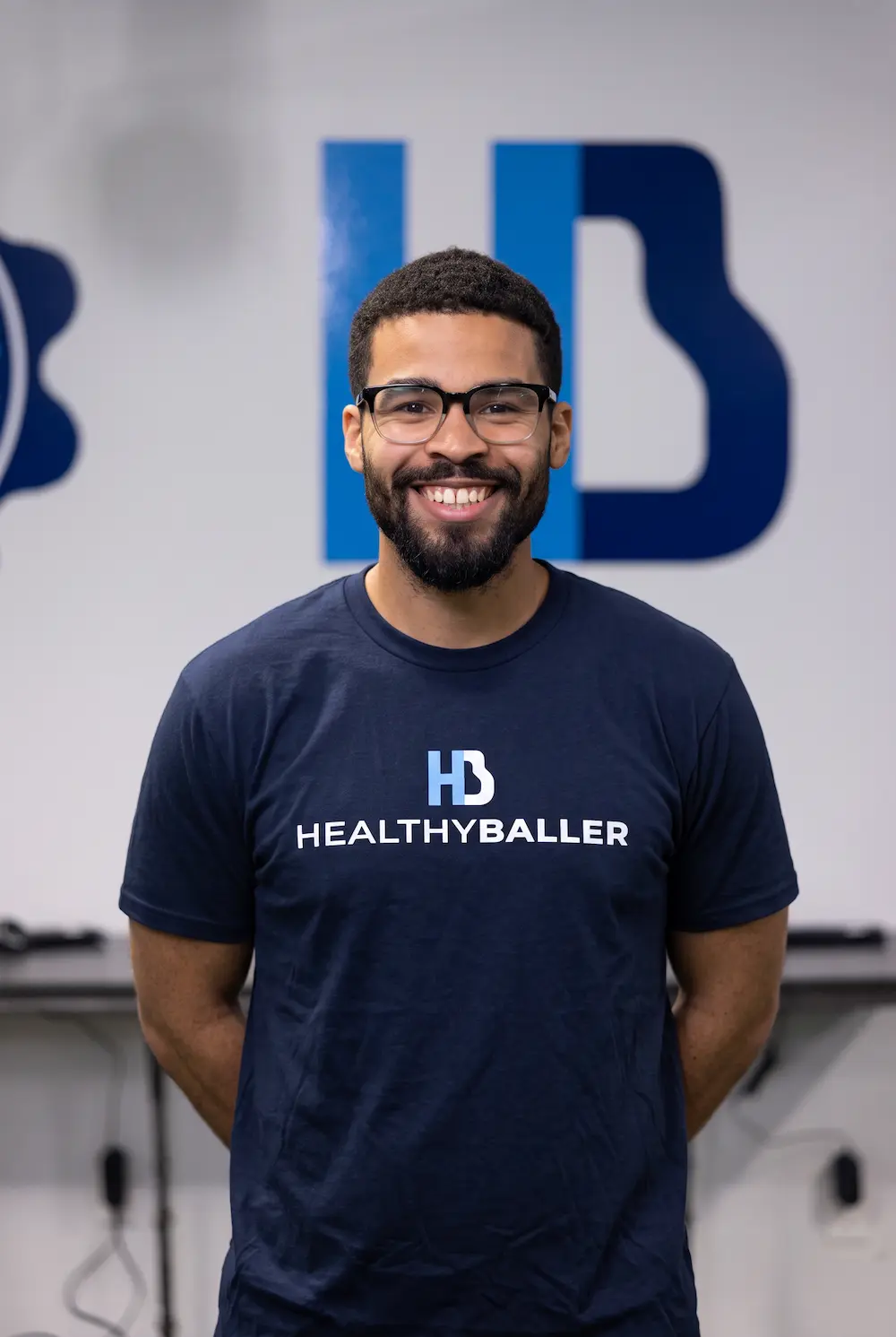 Smiling HealthyBaller staff member wearing branded navy shirt