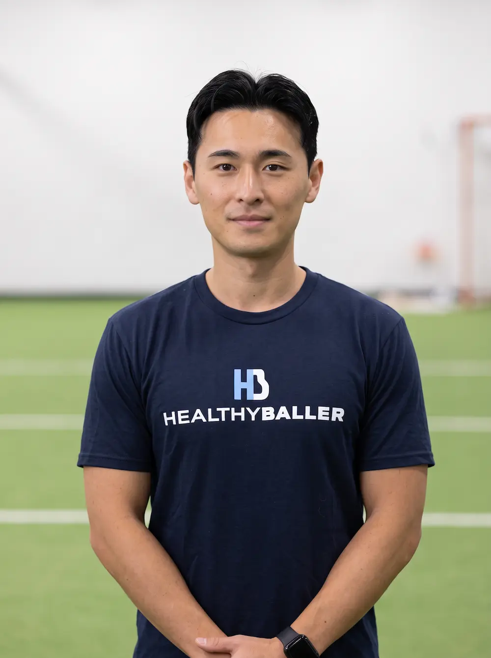 Man wearing HealthyBaller shirt on indoor turf field